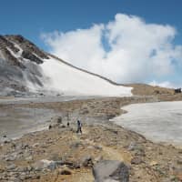 Late-season snow: A lone hiker walks past the frozen Nino Pond to the north of Mount Ontake\'s summit. | TOM FAY