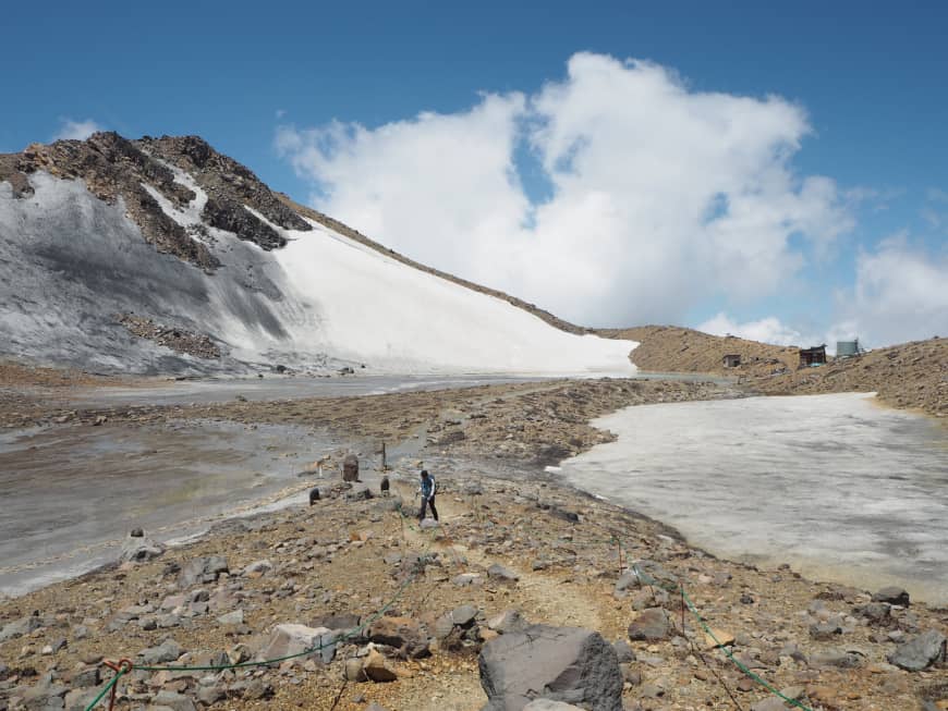 Late-season snow: A lone hiker walks past the frozen Nino Pond to the north of Mount Ontake