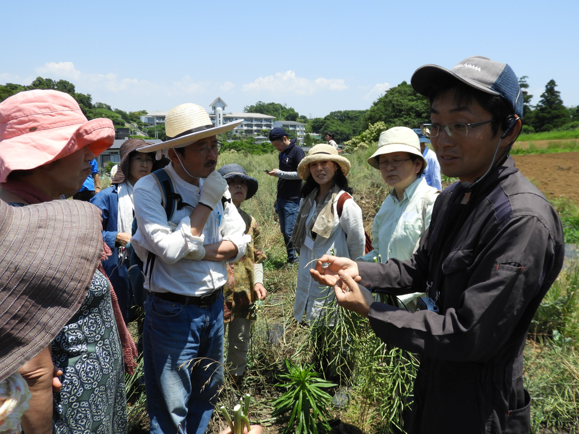 Seeds of change: Hidehito Komaki shows vegetables to visitors on his farm. | JOAN BAILEY