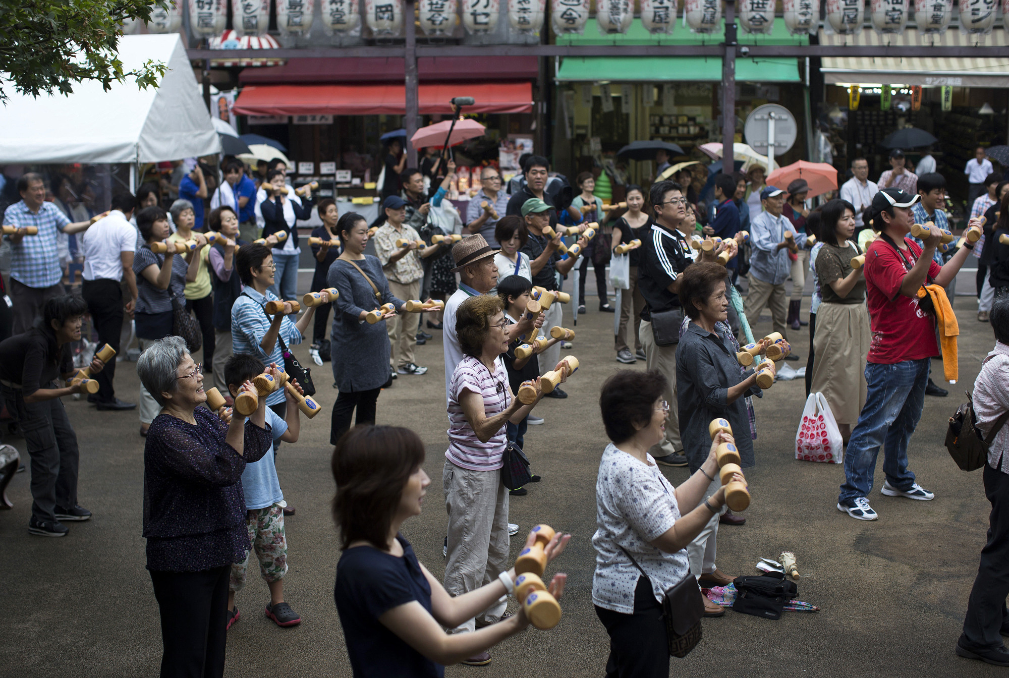 People exercise on Respect for the Aged Day at a temple in the Sugamo neighborhood in Toshima Ward, Tokyo, in September 2016. The proportion of Japan's aged has been rising steadily for decades. | BLOOMBERG
