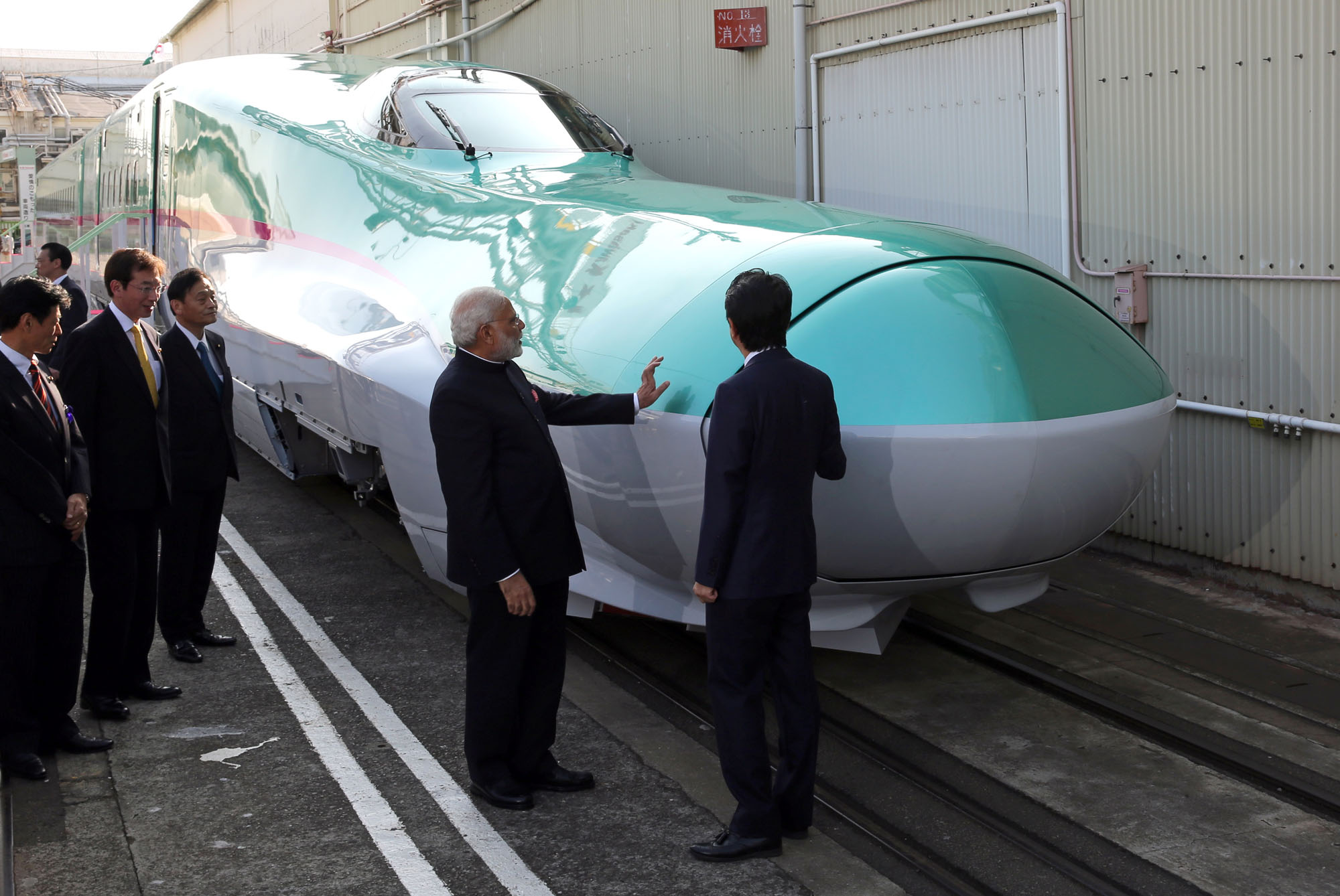 Indian Prime Minister Narendra Modi and Prime Minister Shinzo Abe inspect an E5 series bullet train locomotive at a Kawasaki Heavy Industries plant in Kobe in November 2016. Modi picked Japan as a partner for India's first high-speed rail line. | BLOOMBERG
