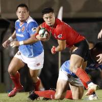 Canon\'s Yu Tamura carries the ball against Toshiba in the teams\' Top League opener on Friday night at Prince Chichibu Memorial Rugby Ground. The Eagles defeated the Brave Lupus 26-20. | KYODO