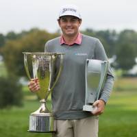 Keegan Bradley holds the championship trophies after winning the BMW Championship in a playoff on Monday at Aronimink. | USA TODAY / VIA REUTERS