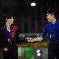 Silver medalist Koshiro Shimada fist bumps winner Camden Pulkinen from the U.S. on the podium at the Junior Grand Prix in Linz, Austria, on Friday. International Skating Union | INTERNATIONAL SKATING UNION