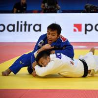 Naohisa Takato (blue) fights against Ryuju Nagayama in the men\'s under-60 kg division at the World Judo Championships in Baku on Thursday. | AFP-JIJI