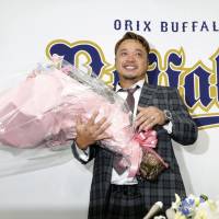Buffaloes infielder Eiichi Koyano is presented flowers during a news conference on Thursday at Kyocera Dome in Osaka. Koyano will retire at the end of the season. | KYODO