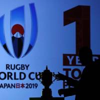 An official reaches out to the Webb Ellis Cup during a kick-off event to mark one year till the Rugby World Cup 2019, in Tokyo last week. | REUTERS