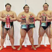 Sumo wrestlers receive various awards on the final day of a tournament. | KYODO