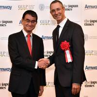 Foreign Minister Taro Kono (left) and Peter Strydom, president of Amway Japan, shake hands during a reception to celebrate the launch of the 2018 Georgetown University Leadership Program at the Cerulean Tower Tokyu Hotel in Tokyo on Sept. 10. | YOSHIAKI MIURA