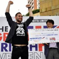 Katsuya Suzuki (right), Aeroflot sales manager for Japan and Australia, presents Fish and Chips Eating Contest winner software engineer Nikolai Egorov with a round-trip airline ticket from Japan to London during The Great British Weekend Tokyo 2017-2020 at Roppongi Hills on Sept. 1. | YOSHIAKI MIURA