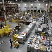 Workers prepare to move products at an Amazon fulfillment center in Baltimore last year. Amazon\'s announcement Tuesday that it will raise its minimum wage to &#36;15 an hour will intensify the pressure on other companies to also lift their pay levels, particularly retailers and warehouse operators that are looking to staff up for the holidays. | AP