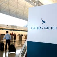 A passenger walks to a Cathay Pacific Airways counter at Hong Kong Airport, Hong Kong, in April. | REUTERS