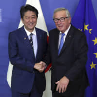 European Commission President Jean-Claude Juncker greets Prime Minister Shinzo Abe in Brussels on Thursday. | AP