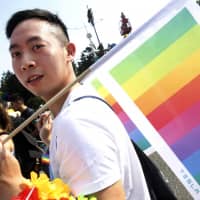 A participant carries a rainbow flag during the annual gay and lesbian parade, organized by Taiwan LGBT Pride, in Taipei on Saturday. | AP