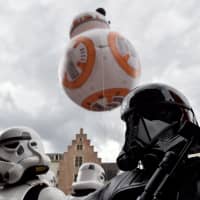 A giant balloon of BB-8 floats behind participants wearing Star Wars costumes during the Balloon Day Parade as part of the Comic Strip Festival in Brussels in September. | REUTERS