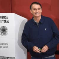 Brazil\'s right-wing presidential candidate, Jair Bolsonaro, smiles after casting his vote at a polling station in Rio de Janeiro on Sunday. | AFP-JIJI