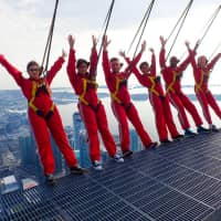 Six new Canadians pose while harnessed to the top of the CN Tower, before taking their oath of citizenship on the \"Edgewalk\" 365 meters (1,668 feet) above Toronto Tuesday. | CN TOWER / HANDOUT / VIA REUTERS