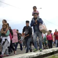 Thousands of Honduran migrants rush across the border toward Mexico from Tecun Uman, Guatemala, on Friday. | AP