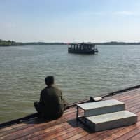 A worker waits for a tour boat to dock at an artificial lake built in a former coal mining district of Xuzhou, Jiangsu province, in September. | REUTERS