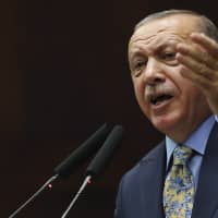 Turkish President Recep Tayyip Erdogan gestures as he addresses members of his ruling Justice and Development Party (AKP) in the parliament in Ankara Tuesday. Turkey\'s president says Saudi officials started planning to murder Saudi writer Jamal Khashoggi days before his death in Saudi Arabia\'s Istanbul consulate. | AP