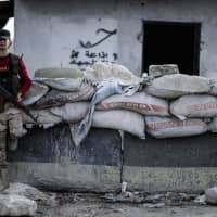 A fighter of the Syrian opposition stands at a checkpoint in northwestern city of Idlib, Syria, late Saturday. Turkey\'s President Recep Tayyip Erdogan suggested Friday Turkey\'s military could soon launch a new operation across northern Syria, in zones held by Syrian Kurdish fighters. | UGUR CAN / DHA / VIA AP