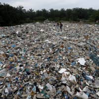 Plastic waste lies outside an illegal recycling factory in Jenjarom, Malaysia, on Oct. 14. | REUTERS