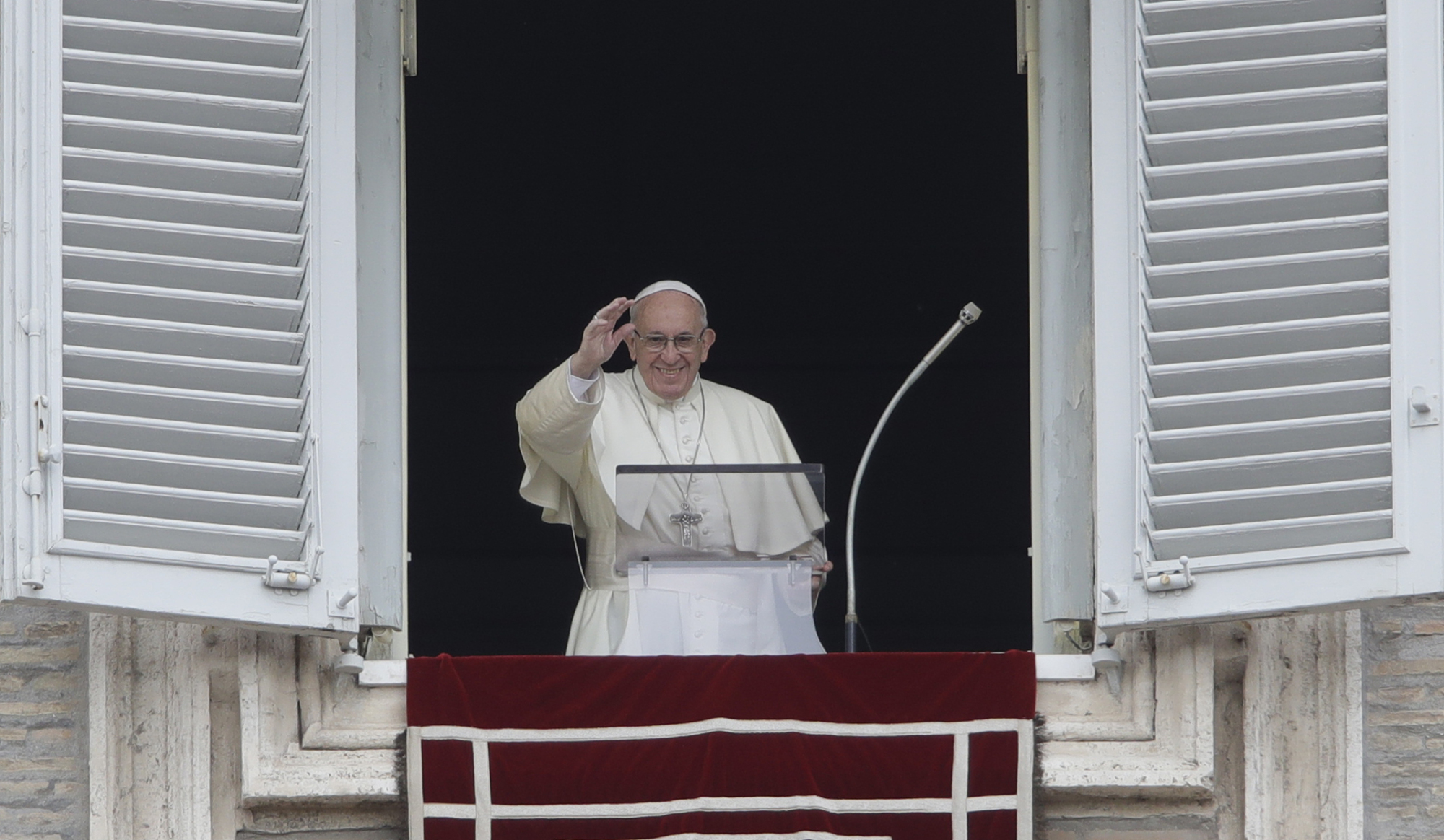 Pope Francis blesses the crowd as he recites the Angelus noon prayer from the window of his studio overlooking St. Peter's Square at the Vatican on Sunday. | AP