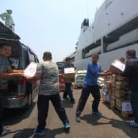 Indonesian navy ranks prepare packages of aid to distribute to victims of the earthquake and tsunami in Palu at Koarmada II port in Surabaya, East Java, Indonesia, Tuesday. | ANTARA FOTO / DIDIK SUHARTONO / VIA REUTERS