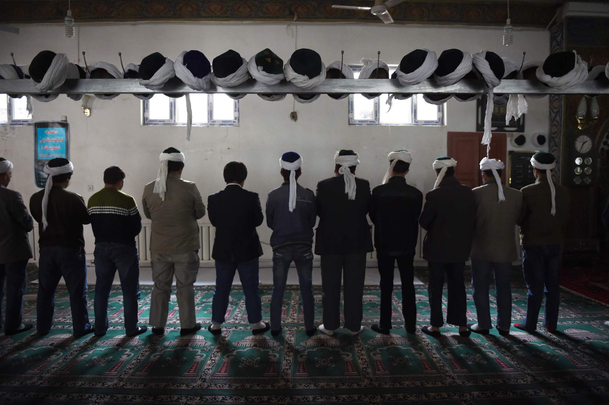 Uighur men pray at a mosque in Hotan, in China's western Xinjiang region, in April 2015. | AFP-JIJI