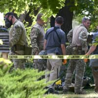 Law enforcement officers search a house on Wednesday in Logan, Utah. A man suspected of mailing ricin to the Pentagon and President Donald Trump was taken into custody at the scene. | ELI LUCERO / HERALD JOURNAL / VIA AP