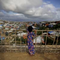 A Rohingya refugee girl stands by a fence at Kutupalong refugee camp, Bangladesh, in August. More than half a million Rohingya children live in the congested camps. | AP