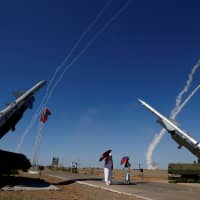 People watch S-300 air defense missile systems launching missiles during the Keys to the Sky competition at the International Army Games 2017 at the Ashuluk shooting range outside Astrakhan, Russia, in 2017. | REUTERS