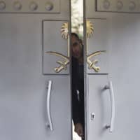 A security officer looks out from the gates of the Saudi Arabian Consulate in Istanbul on Sunday. Writer Jamal Khashoggi vanished after he walked into the consulate on Oct. 2. | AP