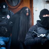 Police escort Alena Zs, a suspect charged with the premeditated murder of Slovak investigative journalist Jan Kuciak and his fiancee, Martina Kusnirova, after a hearing at Specialised Criminal Court in Banska Bystrica, Slovakia, on Sunday. Slovak police detained several people suspected of involvement in the murder of investigative journalist Jan Kuciak months after the reporter\'s violent death and his exposure of alleged high-level corruption sent shockwaves through the country. | AFP-JIJI