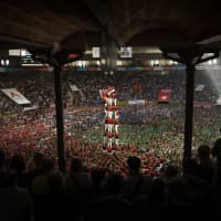 Members of the \"Colla Joves Xiquets de Valls\" try to complete their human tower during the 27th Human Tower Competition in Tarragona, Spain, on Sunday. The tradition of building human towers or \"castells\" dates back to the 18th century and takes place during festivals in Catalonia, where \"colles\" or teams compete to build the tallest and most complicated towers. | AP