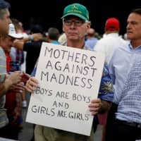 A man holds up a sign supporting North Carolina\'s anti-transgender bathroom law following Republican presidential nominee Donald Trump\' campaign rally in Charlotte, North Carolina, in 2016. | REUTERS