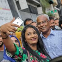 Maldives President-elect Ibrahim Mohamed Solih (center) has his photo taken during celebrations after winning the presidential election held in Male on Saturday. | AFP-JIJI