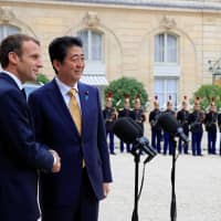 French President Emmanuel Macron (left) and Prime Minister Shinzo Abe pose for a photo in the courtyard of the Elysee Palace in Paris Wednesday. | REUTERS