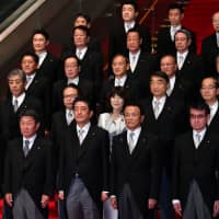 Prime Minister Shinzo Abe and the members of his reshuffled Cabinet at the Prime Minister’s Office on Tuesday. | YOSHIAKI MIURA