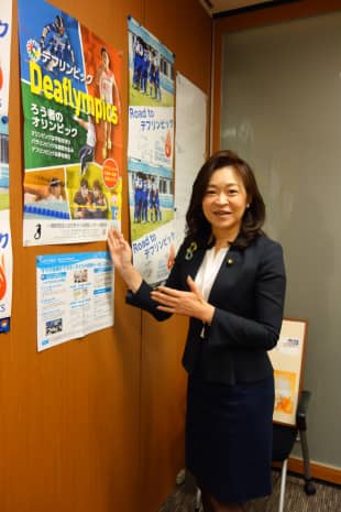 Michiyo Yakushiji, an independent Upper House lawmaker, stands by a poster publicizing the Deaflympics at her office in Tokyo on Sept. 26.