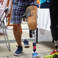 A participant walks with a prosthetic leg to experience how amputees balance their bodies. | MAGDALENA OSUMI