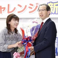 Incumbent Fukushima Gov. Masao Uchibori receives flowers at his election office in the city of Fukushima on Sunday evening as vote counts suggest he has secured a second-term victory in the gubernatorial election held earlier in the day. | KYODO