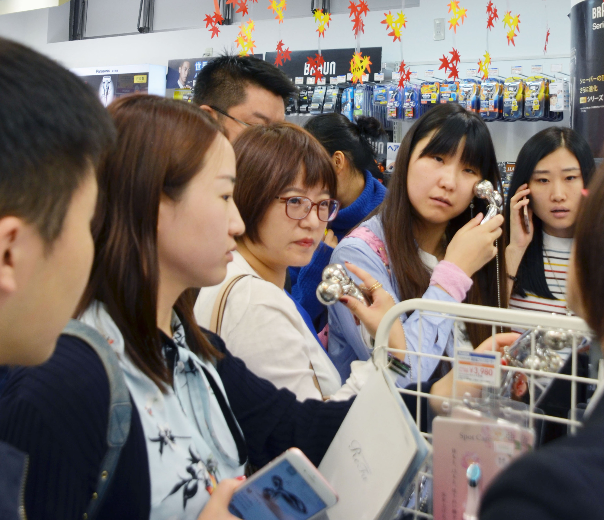 Chinese shoppers check out beauty products at a duty-free store in Tokyo's Akihabara district in 2017. | KYODO