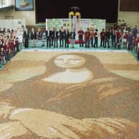 A giant Mona Lisa replica, created with 24,000 senbei rice crackers, is displayed in Soka, Saitama Prefecture, on Sunday. Guinness World Records certified it as the world\'s largest mosaic made of rice crackers. | KYODO