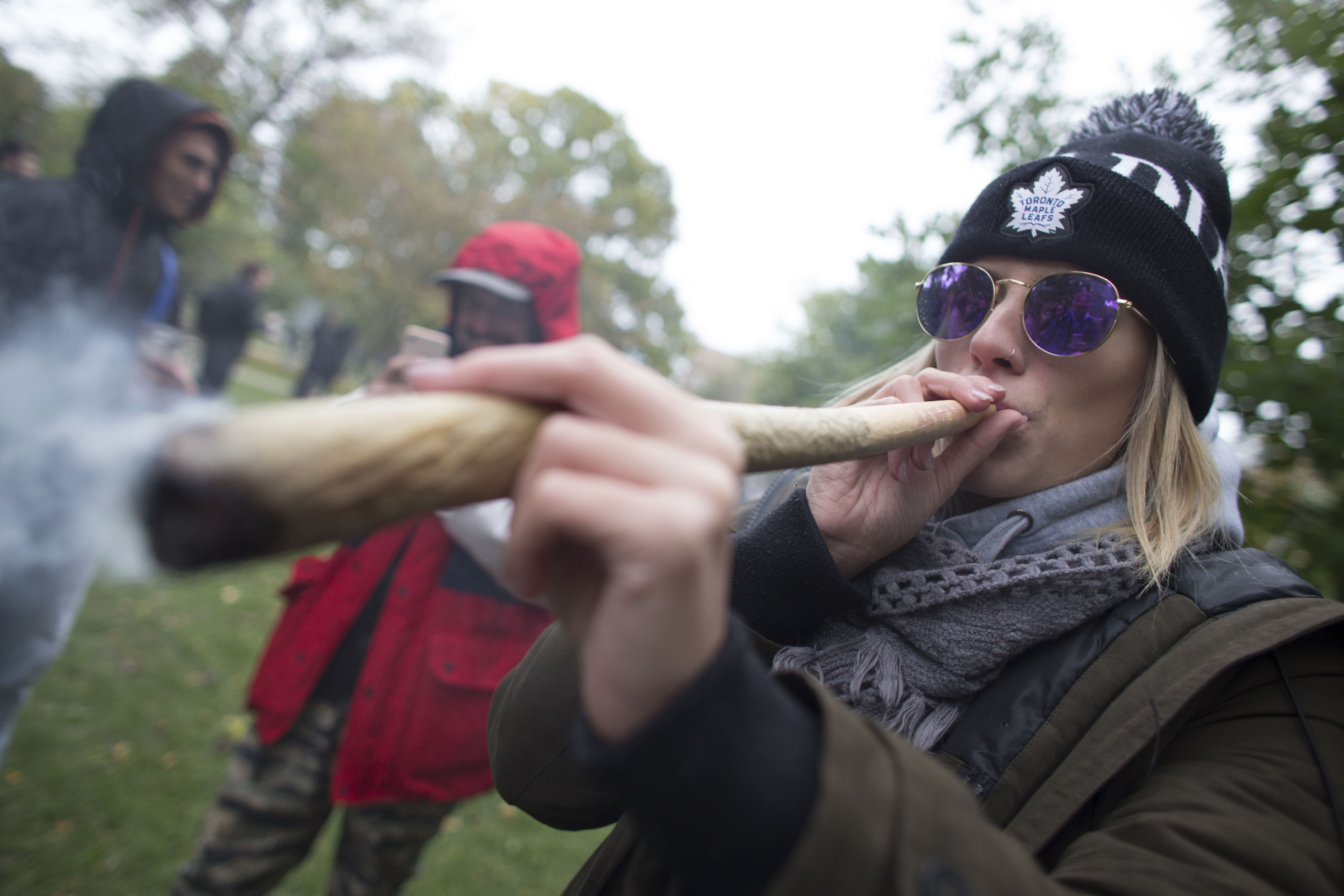 A woman smokes marijuana during a legalization party at Trinity Bellwoods Park in Toronto last Wednesday. | AFP-JIJI