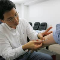 A doctor gives a rubella vaccination to an employee of a company in Atsugi, Kanagawa Prefecture, in May 2013. | KYODO