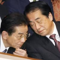 Then-Chief Cabinet Secretary Yoshito Sengoku (left) speaks to Prime Minister Naoto Kan during an Upper House session in November 2010. | KYODO