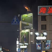 Flames are seen atop a building in Tokyo\'s Shibuya Ward on Wednesday as revelers gathered for massive Halloween celebrations in the area. | KYODO
