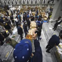 Buyers make bids for vegetables during the first auction at the newly opened fruit and vegetable wholesale section at Toyosu market in Tokyo on Thursday. | AP