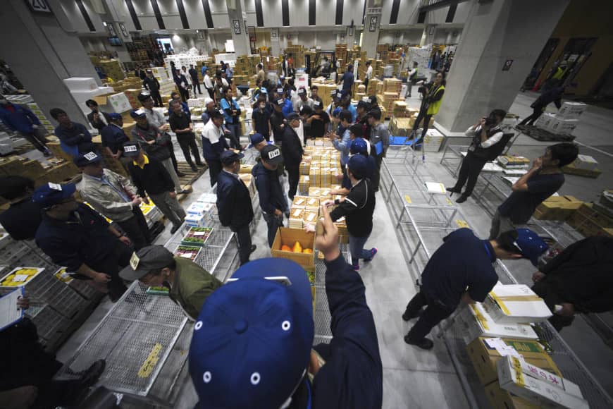 Buyers make bids for vegetables during the first auction at the newly opened fruit and vegetable wholesale section at Toyosu market in Tokyo on Thursday.